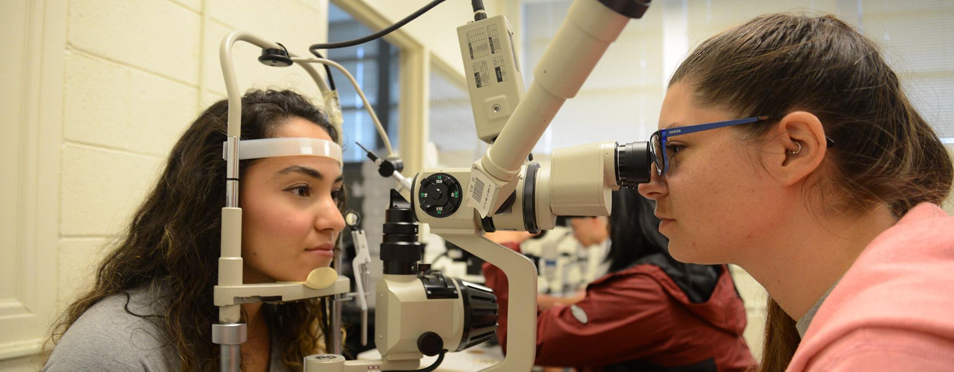 students practice using opticianry equipment in lab
