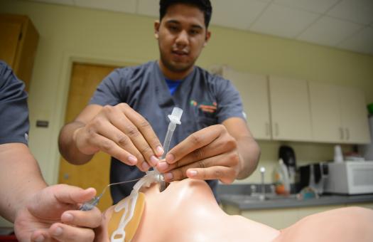 student practicing intubating a mannequin