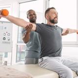 therapist positions athletes arms while lifting weights