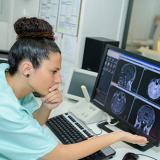 technician views radiologic images while a patient gets an MRI